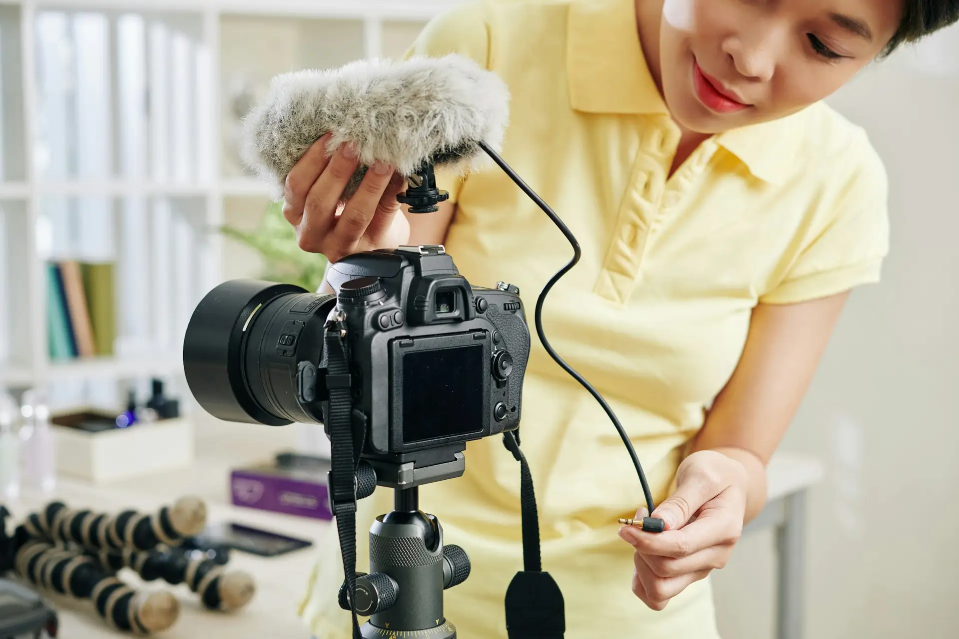 Blogger adjusting microphone to camera