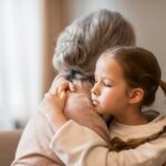 Little Girl Hugging Older Woman on Couch