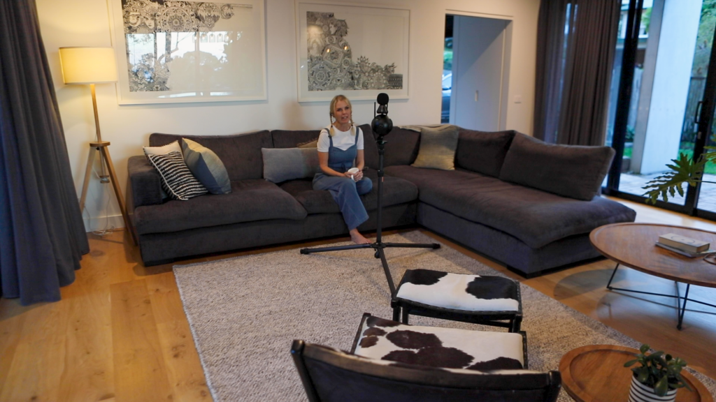 Wide shot of Lisa in her lounge talking to Marvin